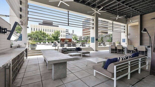 An outdoor seating area with tables and chairs, a pool, and a view of buildings in the background. - Relax, Recharge, Explore. Where Luxury Meets Comfort l The Perfect Atlanta Stay (Atlanta)