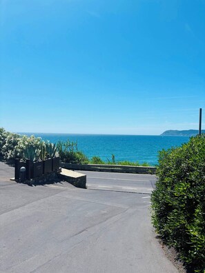 A parking area with a view of the ocean and a distant hill.