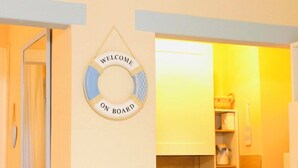 Eine Küche mit einem 'WELCOME ON BOARD'-Schild, einem Spülbecken, Schränken und einer Arbeitsplatte.