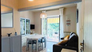 Ein modernes Wohnzimmer mit Sofa, Esstisch und Küchenzeile.