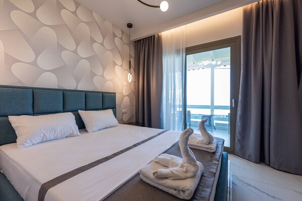 A hotel room with a large bed, a headboard, a window with curtains, and a view of the outside.