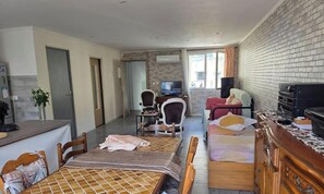 Ein Hotelzimmer mit Essbereich, Fernseher, Bett und einer Ziegelwand.
