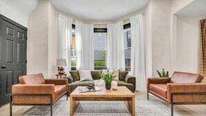 Ein Wohnzimmer mit einer Sofagarnitur, einem Couchtisch und einer Tür.