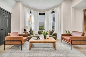 Ein Wohnzimmer mit einer Sofagarnitur, einem Couchtisch und einer Tür.