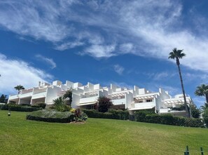 A modern building with a flat roof, surrounded by well-maintained grass and palm trees. - Townhouse in the Fuente del Sol neighborhood - Conil de la Frontera - Cádiz (Conil de la Frontera)