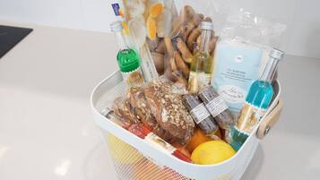 Una cesta con diversos alimentos y botellas, probablemente para una comida o un refrigerio.