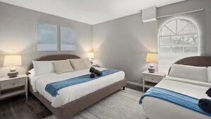 Una camera d'hotel moderna con un letto grande, comodini e una finestra con tende.