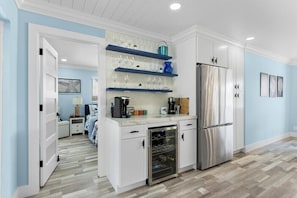 A compact kitchen with white cabinetry, a stainless steel refrigerator, and a wine cooler. - Luxurious home wirh private pool in beautiful Delray Beach upscale neighborhood (Delray Beach)