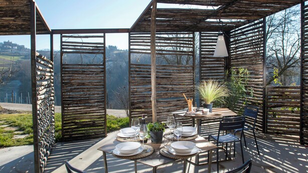 Een terras met een eettafel voor vier personen, omringd door stoelen, met uitzicht op het landschap.