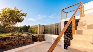 A modern outdoor staircase leading to a building, surrounded by a stone wall and a small tree. - TenoHomes Luxury Hideaway, Buenavista (Buenavista del Norte)