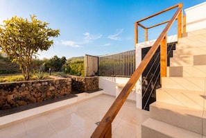 A modern outdoor staircase leading to a building, surrounded by a stone wall and a small tree. - TenoHomes Luxury Hideaway, Buenavista (Buenavista del Norte)