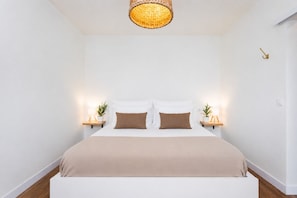 A bedroom with a white bed, two bedside tables with lamps, and a woven light fixture above the bed. - TenoHomes Luxury Hideaway, Buenavista (Buenavista del Norte)