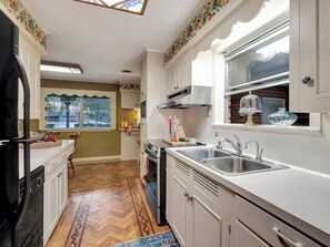A kitchen with white cabinets, a stove, a sink, and a window with a view. - Welcome to The Lawerence House! Full of room and special touches!! (Lufkin)