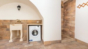 A laundry area with a washing machine, a sink, and a shower. - La Vecchia Grotta - Appartamento by BarbarHouse (Maruggio)