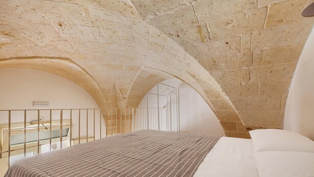 A room with a bed, a window, and an arched ceiling. - La Vecchia Grotta - Appartamento by BarbarHouse (Maruggio)