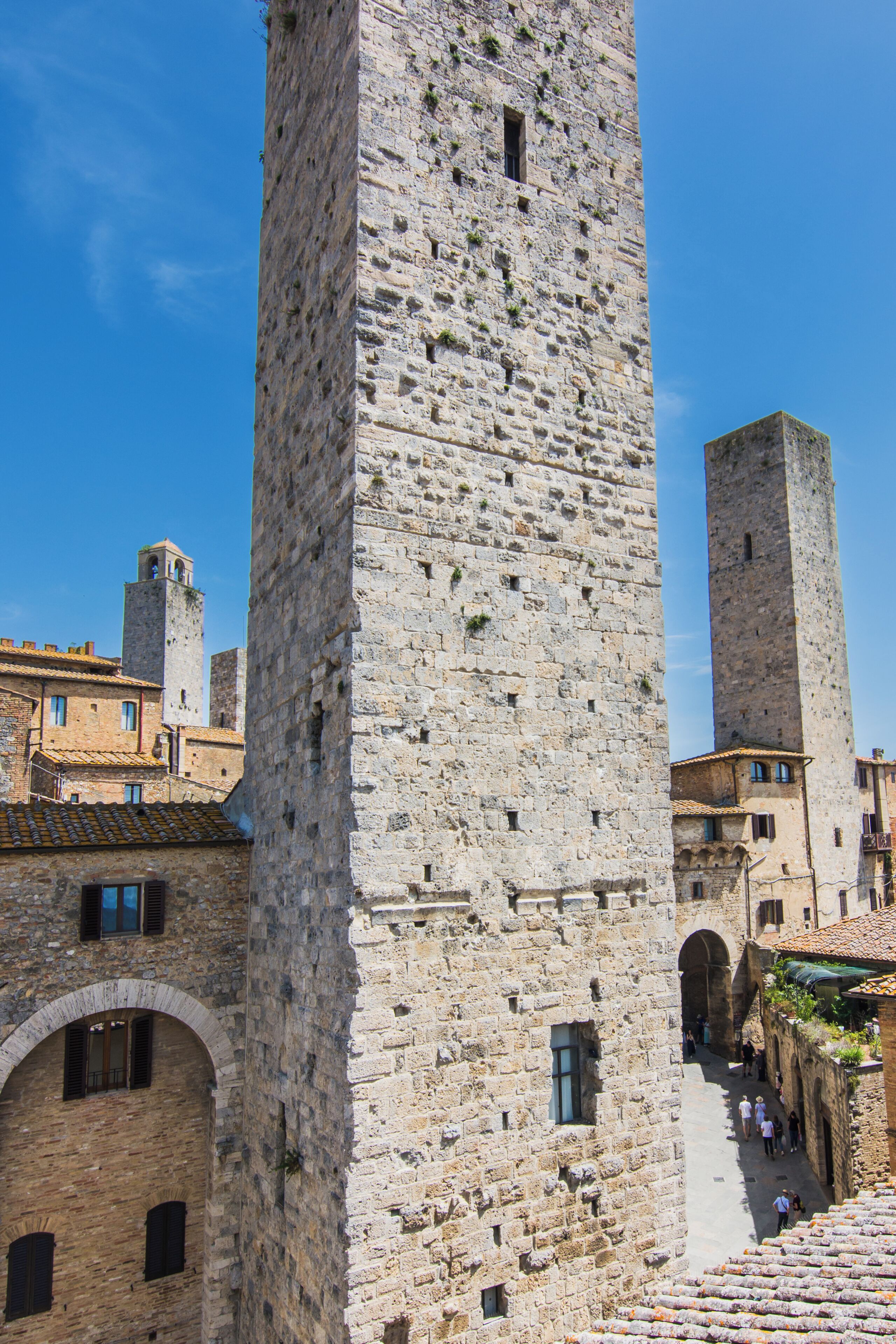 Ein historischer Steinturm mit Rundbogenfenstern und einem schmalen Durchgang.