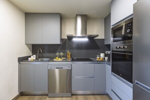 Una cocina moderna con lavavajillas, horno y armarios de acero inoxidable.