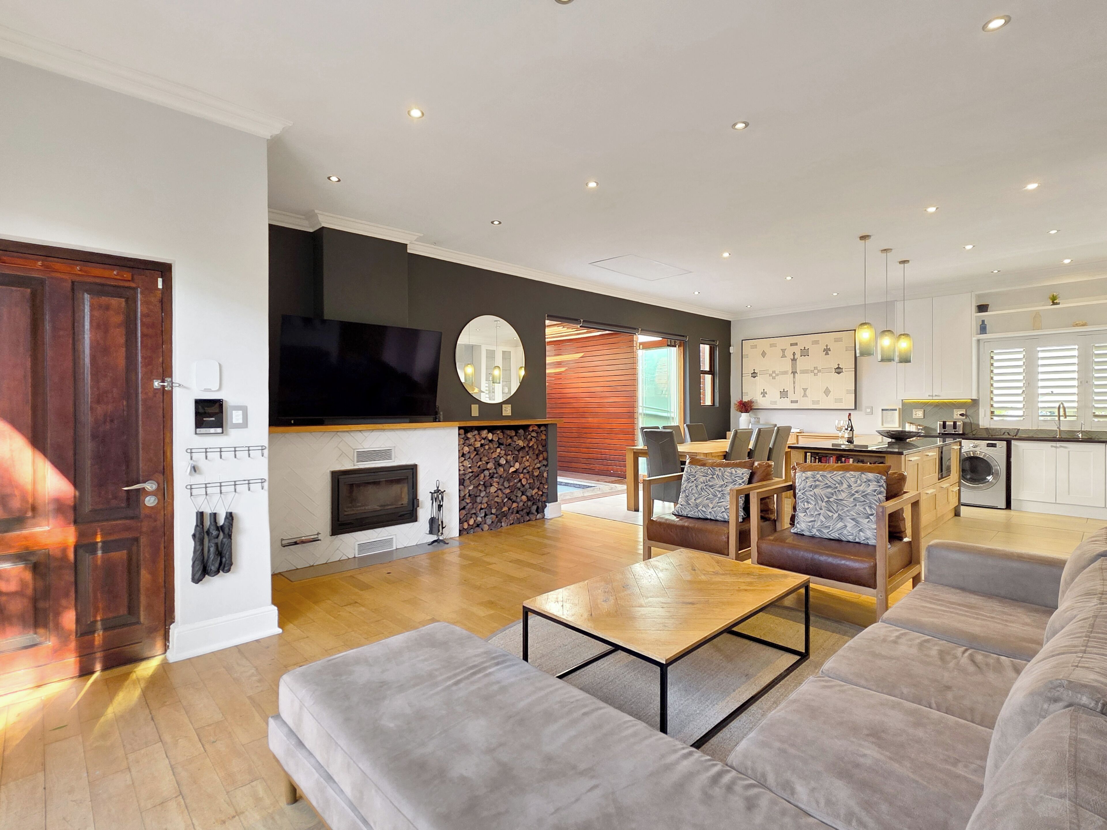 A modern living room with a fireplace, a television, and a dining area with a table and chairs.