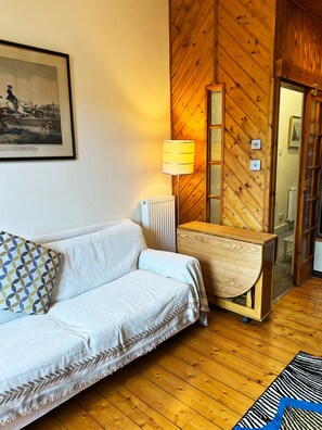 A room with a white sofa, a lamp, a wooden cabinet, and a framed picture on the wall. - Flat, Arthur Seat view, walking distance to Castle (Edinburgh)