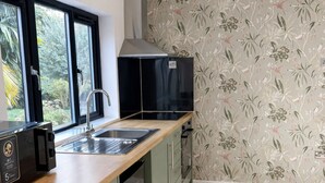 A kitchen with a wooden countertop, a sink, a black microwave, and a stove. - Spacious 2-BR Annexe near Abington Park - 10% off (West Northamptonshire)