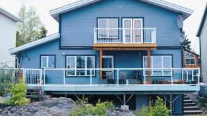 A two-story house with a balcony, satellite dishes, and a wooden deck.