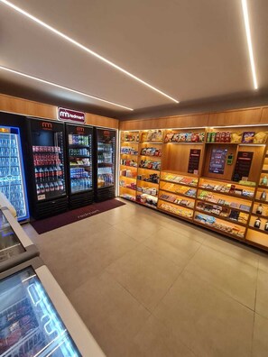 A Redmart store with refrigerated beverage dispensers, snack shelves, and a Redmart logo. - F.206 | Your Refuge with comfort and good taste (Tamandaré)