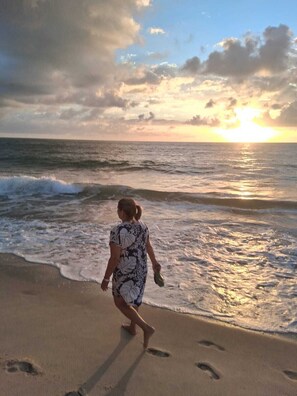 A person walking on a beach with the ocean and a sunset in the background. - F.206 | Your Refuge with comfort and good taste (Tamandaré)