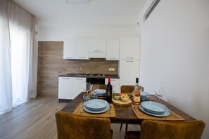 Ein Essbereich mit Holztisch, Stühlen und einer Küche im Hintergrund.