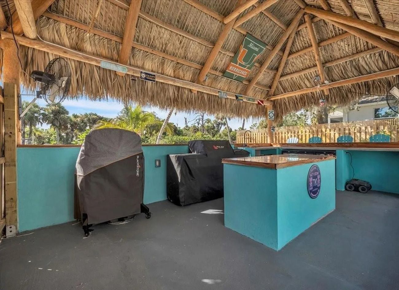 Een overdekt buitengebied met rieten dak, een bar en overdekte zitplaatsen.