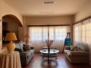 A living room with two sofas, a coffee table, and a painting on the wall.