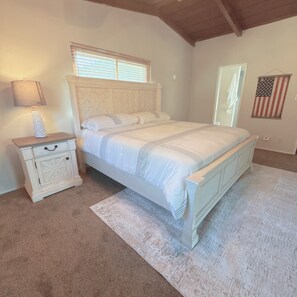 A bedroom with a bed, nightstand, lamp, and American flag. - The Bridge at Springville PRIVATE RIVER ACCESS Sierra Foothills Near Sequoias (Springville)