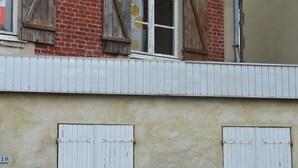 A building with a brick facade, white shutters, and a visible number '10' on the wall.