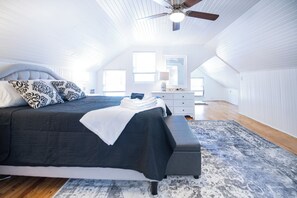 A bedroom with a bed, bedside table, lamp, and a ceiling fan. - 1 Block Off Main Downtown Greenville (Greenville)