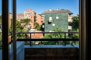 A balcony with a metal railing overlooking a cityscape with buildings and trees. - Sophisticated Venice Lido Apartment Moments from the Beach (Lido)