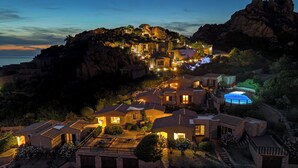 A coastal resort with multiple buildings, a swimming pool, and a rocky hillside backdrop. - Solo Amore 2 Villa in the Costa Paradiso Sardinia Resort with a Pool (Costa Paradiso)