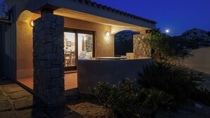 A modern house with stone walls, a patio, and a view of the night sky. - Solo Amore 2 Villa in the Costa Paradiso Sardinia Resort with a Pool (Costa Paradiso)