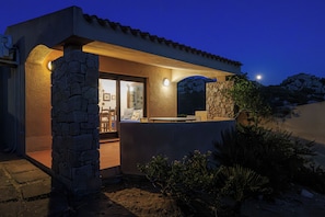 A modern house with stone walls, a patio, and a view of the night sky. - Solo Amore 2 Villa in the Costa Paradiso Sardinia Resort with a Pool (Costa Paradiso)