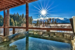 A hot tub with a clear view of a snowy mountain landscape and a bright sun. - Lakeview Grand Lodge | Rooftop Deck | Theater (South Lake Tahoe)