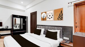 Una habitación de hotel moderna con una cama grande, una mesita de noche y un espejo.