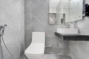 Ein Badezimmer mit Toilette, Waschbecken, Spiegel und Dusche.
