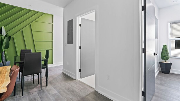 A modern interior with a dining area, a green accent wall, and a potted plant. - Hyde Park 1/1 private residence 12 (Tampa)
