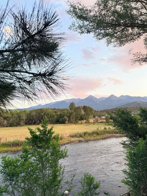 A river with a mountainous backdrop, surrounded by greenery and trees. - Pleasant Valley RV (Howard)