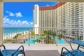 A hotel balcony with a view of a swimming pool and beach. -  Stunning, updated beach condo with breathtaking ocean, pool and sunset views! (Panama City Beach)