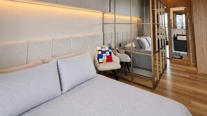 A modern bedroom with a large bed, a seating area with a sofa and chairs, a mirrored wardrobe, and a small kitchenette. - Millenium Luxury Cozy Studio in Vila Ol Mpia (São Paulo)