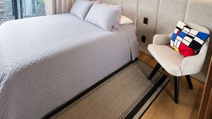 A modern hotel room with a large bed, a chair, a nightstand, and a view of the city. - Millenium Luxury Cozy Studio in Vila Ol Mpia (São Paulo)