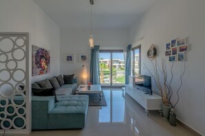 Ein modernes Wohnzimmer mit einer Couch, einem Fernseher und Kunstwerken.