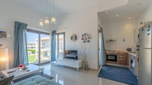 A modern living room with a sofa, a TV, and a dining area. - Gcribs apartment pool view (Hurghada)