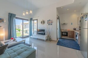 Ein modernes Wohnzimmer mit Sofa, Fernseher und Essbereich.