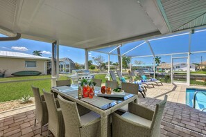 An outdoor patio with wicker furniture, a grill, and a pool. - Modern vacation home on the canal with a saltwater pool and private dock in the yacht club area (Cape Coral)