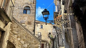A narrow stone street with a cobblestone path, stone buildings, and a traditional street lamp. - Maiella Experience - Downtown Apartment, Nestled in the Maiella Mountains (Campo di Giove)